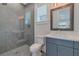 Contemporary bathroom with a glass-enclosed shower featuring decorative tile and blue vanity with a stone countertop at 140 Johnson Rd, Suwanee, GA 30024