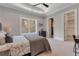 Comfortable bedroom featuring a ceiling fan, large window, a gray and patterned bedspread, and ensuite bath at 140 Johnson Rd, Suwanee, GA 30024