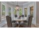 Bright breakfast nook with large windows overlooking lush greenery and contemporary light fixture at 140 Johnson Rd, Suwanee, GA 30024