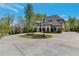 Beautiful two-story home with a circular driveway surrounded by lush greenery at 140 Johnson Rd, Suwanee, GA 30024