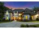 Inviting brick and stucco home with warm lighting and beautiful landscaping at twilight at 140 Johnson Rd, Suwanee, GA 30024