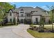 Elegant brick and stucco home featuring a circular driveway and manicured landscaping at 140 Johnson Rd, Suwanee, GA 30024