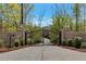 Private entrance gate featuring brick pillars, lush shrubbery, and secure entry at 140 Johnson Rd, Suwanee, GA 30024