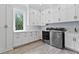 Laundry room featuring white cabinets, stainless steel appliances, a window, and a light gray floor at 140 Johnson Rd, Suwanee, GA 30024