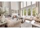Inviting living room with high ceilings, large windows, a cozy fireplace and elegant furnishings at 140 Johnson Rd, Suwanee, GA 30024