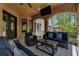 Covered brick patio with comfortable seating and a ceiling fan for outdoor living at 140 Johnson Rd, Suwanee, GA 30024