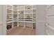 This pantry includes pull-out drawers, an open shelving system, and hardwood floors at 140 Johnson Rd, Suwanee, GA 30024