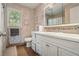 Well-lit bathroom featuring a white vanity, framed mirror, window, and tile flooring at 180 Spring Ridge Trace, Roswell, GA 30076