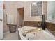 Bright bathroom featuring a corner soaking tub with marble surround and a geometric glass block window at 180 Spring Ridge Trace, Roswell, GA 30076