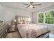 Bedroom featuring large window and a dresser to the left of a queen bed with silver upholstery at 180 Spring Ridge Trace, Roswell, GA 30076