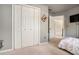 Bright bedroom featuring carpeted floors, and a large closet with white bi-fold doors at 180 Spring Ridge Trace, Roswell, GA 30076