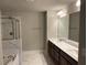 Elegant bathroom with a soaking tub, glass shower, double vanity, and marble-like tile flooring at 2458 Morgan Creek Rd, Buford, GA 30519