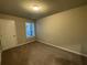 Bright bedroom with tan carpet, neutral walls, and window with view at 2458 Morgan Creek Rd, Buford, GA 30519