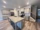 Open-concept kitchen with an island, gray cabinets, hardwood floors, and stainless steel appliances at 2458 Morgan Creek Rd, Buford, GA 30519