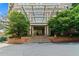 Grand entrance to the building with a covered walkway, lush greenery, and brick features at 2626 Peachtree Nw Rd # 606, Atlanta, GA 30305