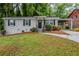 Charming single-story home with painted brick, black shutters, a cozy front porch, and lush landscaping at 2796 Green Trail Dr, Atlanta, GA 30349