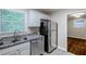 View of kitchen with stainless steel appliances, granite countertops, white cabinets, and access to the dining room at 2796 Green Trail Dr, Atlanta, GA 30349