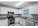 Modern kitchen features stainless steel appliances, granite countertops, white cabinets, and tiled floors at 2796 Green Trail Dr, Atlanta, GA 30349