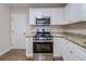Updated kitchen features a stainless steel range, microwave, granite countertops, and white cabinets at 3497 Glensford Dr, Decatur, GA 30032