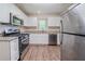 Updated kitchen featuring stainless steel appliances, granite countertops, and wood-look flooring at 3497 Glensford Dr, Decatur, GA 30032