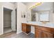 Bathroom featuring dual sinks, framed mirrors, stylish light fixture and door leading to a large walk-in closet at 1452 Evanston Ln, Marietta, GA 30062