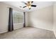 Bedroom featuring a ceiling fan, light-colored walls, carpet flooring and large window with horizontal blinds and curtains at 1452 Evanston Ln, Marietta, GA 30062