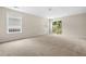 Bright living room with two large windows and sliding glass door and neutral-toned carpet and walls at 1452 Evanston Ln, Marietta, GA 30062