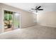 Neutral living room featuring sliding glass door with a view, ceiling fan, carpet flooring and a window at 1452 Evanston Ln, Marietta, GA 30062