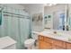 This bathroom features a shower with a curtain, light wooden cabinets and a sink with plenty of counter space at 2602 Midler Ct, Buford, GA 30519