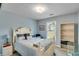 Cozy bedroom featuring a queen bed, soft blue walls, a large window, and a glass desk creating a tranquil retreat at 2602 Midler Ct, Buford, GA 30519