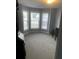 An empty room bathed in natural light, showcasing a bay window and plush carpeting, ready for personalization at 2602 Midler Ct, Buford, GA 30519