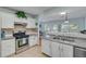 Modern kitchen featuring white cabinets, stainless steel appliances, and an opening to the dining area at 2602 Midler Ct, Buford, GA 30519