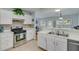 Cozy kitchen featuring white cabinets, stainless steel appliances, and an opening to the dining area at 2602 Midler Ct, Buford, GA 30519