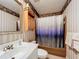 Cozy bathroom with striped wallpaper, a shower-tub combo, and a vintage-style vanity sink at 3220 Stoney Acres Nw Dr, Kennesaw, GA 30152