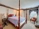 Primary bedroom featuring a four-poster bed, cozy chair, and decorative wallpaper border at 3220 Stoney Acres Nw Dr, Kennesaw, GA 30152