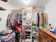 Walk-in closet filled with clothes, shoes, and accessories, along with a dresser for folded items at 3220 Stoney Acres Nw Dr, Kennesaw, GA 30152