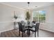 Dining room with modern lighting, hardwood floors, and a large window with natural light and neighborhood view at 5447 Lauren Cv, Ellenwood, GA 30294