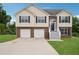 Charming two-story home with brick and vinyl siding, an arched front door, and a two-car garage at 5447 Lauren Cv, Ellenwood, GA 30294