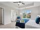 Bright main bedroom features a tray ceiling, neutral tones, a ceiling fan, and a sunny window view at 5447 Lauren Cv, Ellenwood, GA 30294