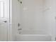 Clean, all-white bathroom showcasing a soaking tub with shower fixture and tiled walls at 4100 Paces Se Walk # 4306, Atlanta, GA 30339