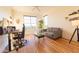 Bright bedroom featuring hardwood floors, large windows and a cozy sitting area with modern desk and light gray loveseat at 4100 Paces Se Walk # 4306, Atlanta, GA 30339