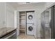 Efficient laundry closet with stacked washer/dryer and storage shelves, next to stainless steel refrigerator at 4100 Paces Se Walk # 4306, Atlanta, GA 30339