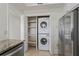 Convenient laundry closet with stackable washer and dryer, and open shelving next to a stainless steel fridge at 4100 Paces Se Walk # 4306, Atlanta, GA 30339