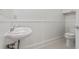Elegant powder room featuring beadboard walls, pedestal sink, and tile flooring at 4100 Paces Se Walk # 4306, Atlanta, GA 30339