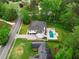Aerial view of a modern farmhouse with an inviting pool and an outdoor kitchen at 575 Indian Hills Pkwy, Marietta, GA 30068