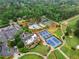 Scenic aerial view of a golf course community highlighting tennis courts, a pool, and lush greenery at 575 Indian Hills Pkwy, Marietta, GA 30068