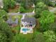 Beautiful aerial view of a modern farmhouse with a pool, outdoor kitchen, and lush landscaping at 575 Indian Hills Pkwy, Marietta, GA 30068