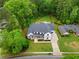 Expansive aerial view of a modern farmhouse with lush green landscaping and mature trees at 575 Indian Hills Pkwy, Marietta, GA 30068