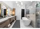 Modern bathroom featuring a freestanding tub, an open shower, dual vanities, quartz countertops, and sleek, modern lighting at 575 Indian Hills Pkwy, Marietta, GA 30068