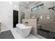 Contemporary bathroom with a soaking tub, frameless glass shower, neutral color palette, and modern black hardware at 575 Indian Hills Pkwy, Marietta, GA 30068